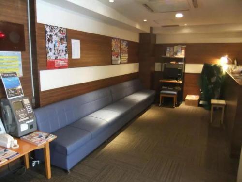 那霸Hotel Kokusai Plaza - Vacation STAY 09932v的一间位于商店的带蓝色沙发的等候室