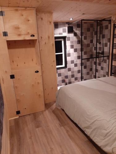 VledderDe Boshut Vledder的一间卧室设有一张床和一面墙,墙壁上设有格子