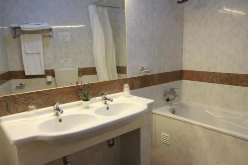 维迪盖拉Hotel Santa Clara的一间带水槽、浴缸和镜子的浴室