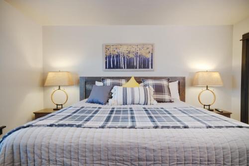 比尤特Copper King Extended Stay Collection的一间卧室配有一张带两盏灯的蓝色和白色的床。