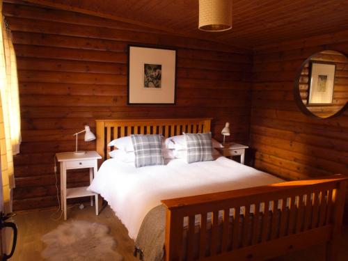 斯特拉西尔Hillside Log cabin, Ardoch Lodge, Strathyre的小木屋内一间卧室,配有一张床