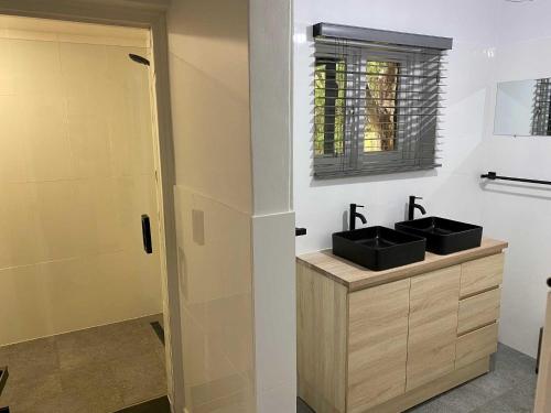 阿德莱德阿德莱德旅游公园酒店的一间带两个盥洗盆和淋浴的浴室