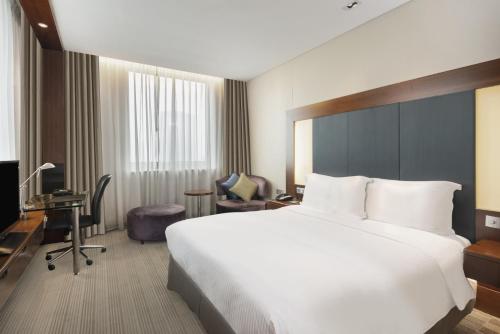 上海上海浦东假日酒店的酒店客房设有一张白色大床和一张书桌