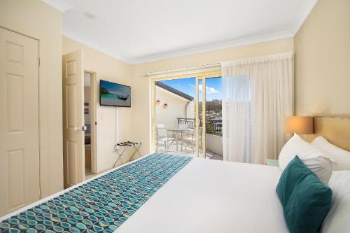特里格尔特里高帆船服务式公寓酒店的酒店客房设有一张床和一个阳台。