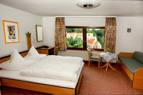 Haigerloch克朗酒店的一间卧室配有一张床、一张沙发和一张桌子