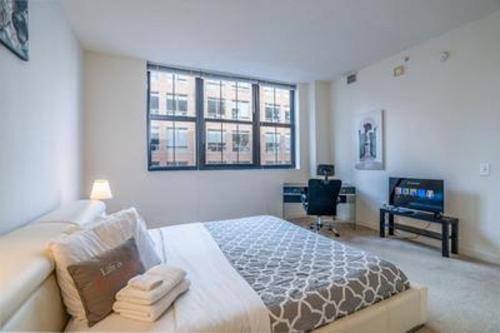 巴尔的摩巴尔的摩港畔希文公寓的一间卧室配有一张大床和电视