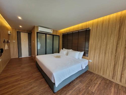 拉廊Sunnyvale Ranong 2的卧室配有一张白色大床和木墙