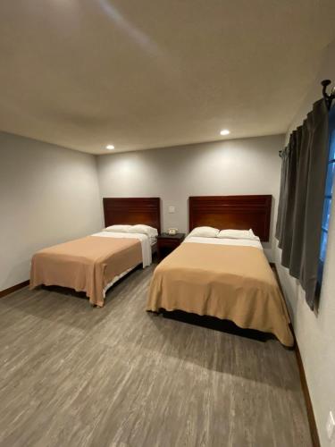 洛杉矶Sandman Motel的客房设有两张床和窗户。