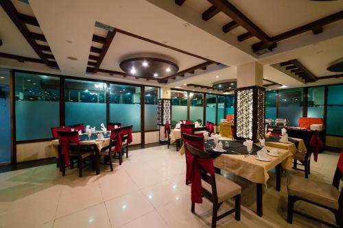 伊斯兰堡Laraib Inn Hotel的用餐室设有桌椅和窗户。