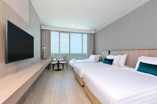 呵叻Centre Point Hotel Terminal21 Korat的酒店客房设有两张床和一台平面电视。