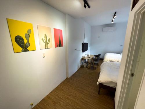 台南小岛民宿的一间设有一张床的客房,墙上挂有绘画作品