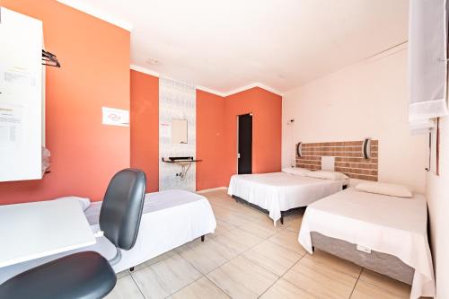 索罗卡巴Hotel Campolim的一间设有两张床和橙色墙壁的客房