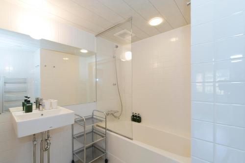 二世古二世古小屋酒店的白色的浴室设有水槽和淋浴。
