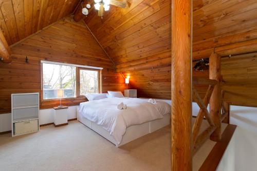 二世古二世古小屋酒店的小木屋内一间卧室,配有一张大床