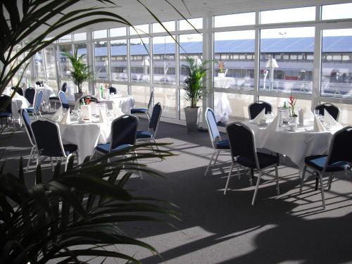 霍根海姆莫托杜姆酒店的配有白色桌椅和窗户的客房