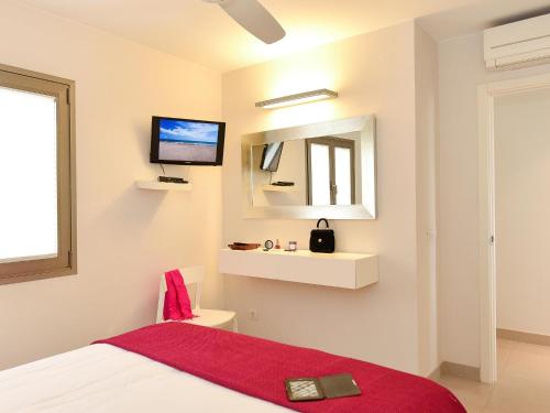 圣阿古斯丁圣奥古斯丁海滩公寓酒店的卧室配有一张床,墙上配有电视。
