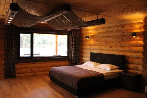 KorostyshivCharivne Ozero的小木屋内一间卧室,配有一张床