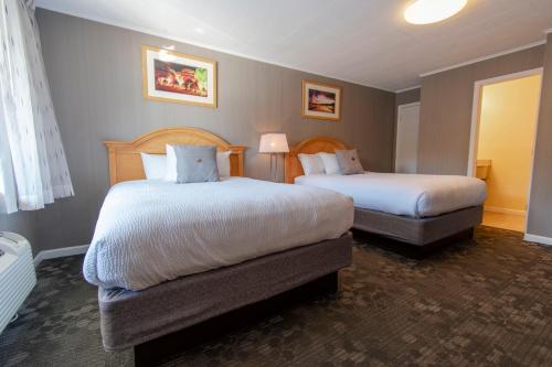 乔治湖海洋村度假酒店的酒店客房设有两张床和窗户。