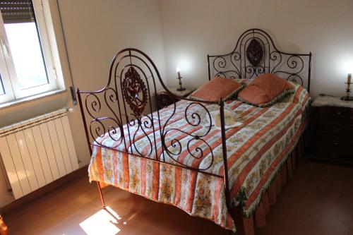 雷森迪Casa do Passarinho的一间卧室配有一张带锻铁框架的床