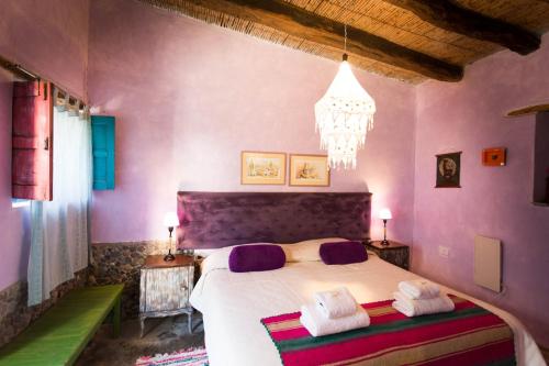 卡奇卡奇维拉科查艺术旅舍的一间卧室配有一张带紫色墙壁和吊灯的床。