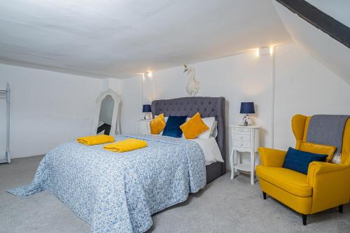 埃文河畔斯特拉特福5 Central Chambers的一间卧室配有一张床和一张黄色椅子