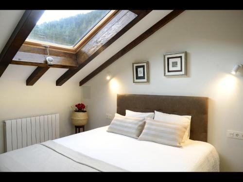AulestiaCasa Rural Andikoetxe Landetxea的卧室配有一张白色大床和天窗