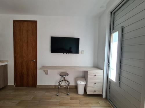 墨西哥城Acogedor loft privado的一间设有卫生间的客房,墙上设有一台电视机