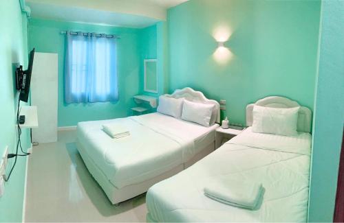 南府Lomluang hostel&hotel的蓝色墙壁客房的两张床
