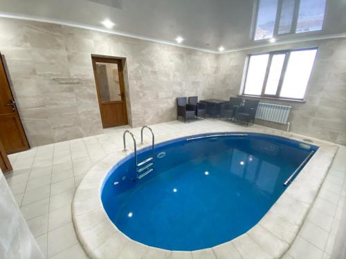 休钦斯克Алатау的大型浴室设有大型蓝色浴缸。
