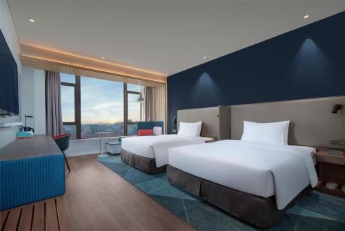 晋江晋江安海智选假日酒店的酒店客房设有两张床和窗户。