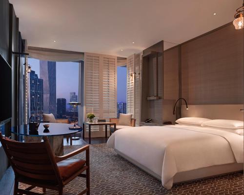 深圳深圳湾安达仕酒店(入住享受免费迷你吧，酒廊礼遇，及欢迎水果）的一间卧室配有一张床和一张书桌,另一间享有美景。
