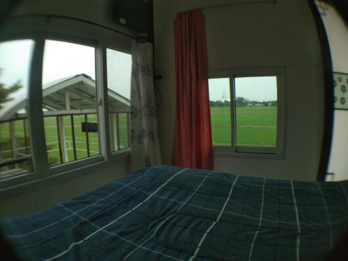 大城安萨亚慢生活旅馆的一间卧室设有2扇窗户和1张带蓝色毯子的床