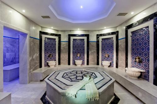 马尔马里斯Quadas Hotel - Adult Only的浴室设有浴缸和蓝色瓷砖淋浴。