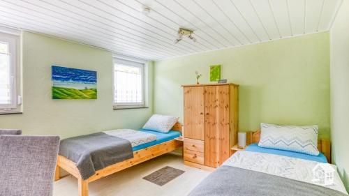 内托芬Pension zum Rothaarsteig Selbstversorgerhaus的绿墙客房内的两张床