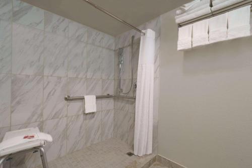 布雷默顿布雷默顿贝蒙特旅馆套房酒店的一间带白色淋浴帘的浴室