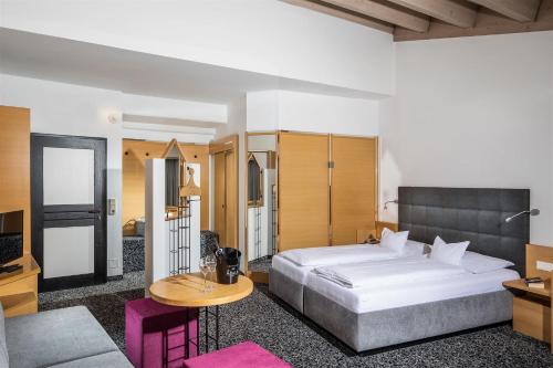 东蒂罗尔地区马特赖鲁特酒店的一间卧室配有一张大床和一张桌子