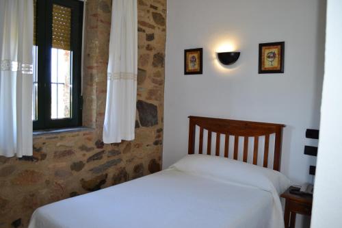 Encinasola林孔阿贝德酒店的一间卧室设有一张床和一个窗口