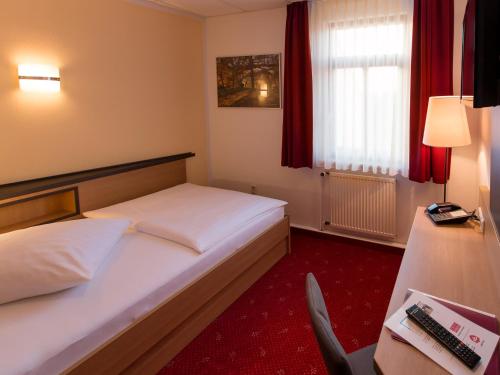 阿尔滕堡Hotel Pension Treppengasse Nr. 5的配有一张床和一把椅子的酒店客房
