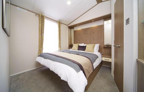 南塞尔尼Lavender Lodge的一间卧室设有一张大床和一个窗户。