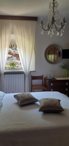 BeuraA casa di Lara的卧室配有一张带两个枕头的床和窗户