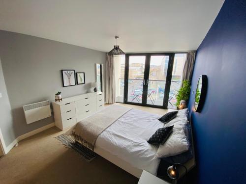 切尔滕纳姆Stewart St James Walk Apartment的一间卧室设有一张大床和一个大窗户