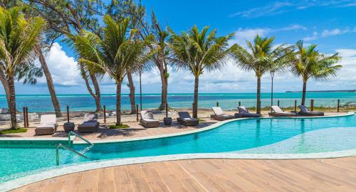 若昂佩索阿Oceana Atlântico Hotel的一座棕榈树和椅子的游泳池以及大海