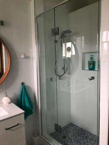 麦夸里港Fi's Beach House的浴室里设有玻璃门淋浴