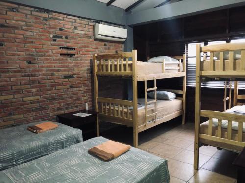 蒙塔尼塔塔瓦鲁亚酒店的带两张双层床和砖墙的客房