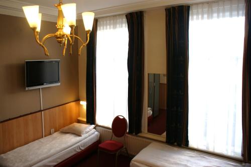 阿姆斯特丹维斯特图伦酒店的酒店客房设有两张床和一台墙上的电视。