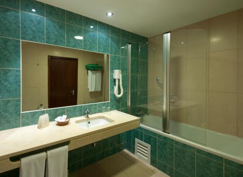 卡尼索洛克玛酒店的一间带水槽、淋浴和镜子的浴室