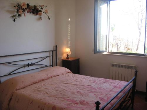 穆尔洛Villa Righino的一间卧室配有一张带粉色毯子的床和窗户。