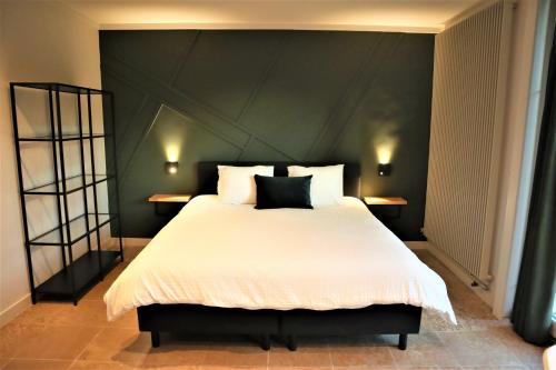 布鲁日B&B Fago的一间卧室配有一张大床和黑色床头板