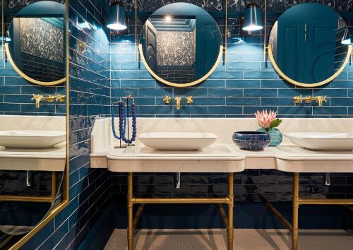 西萨默塞特埃林维尔庄园酒店及水疗中心的浴室设有2个水槽和蓝色瓷砖