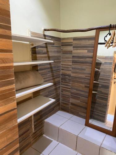 费尔南多 - 迪诺罗尼亚Casa do Ney的步入式淋浴间设有木墙和架子